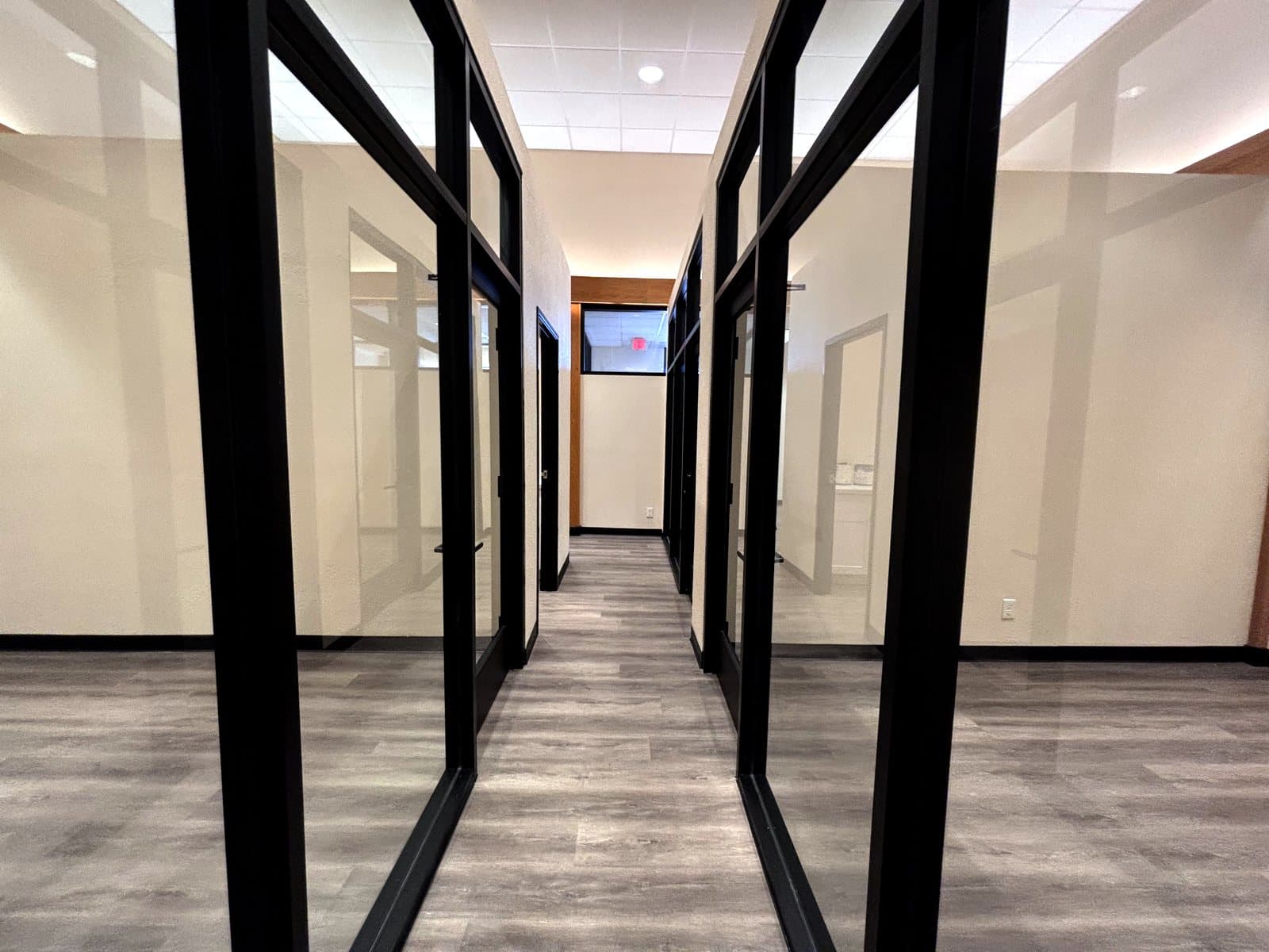 Corridor of finished black-framed glass office walls and doors