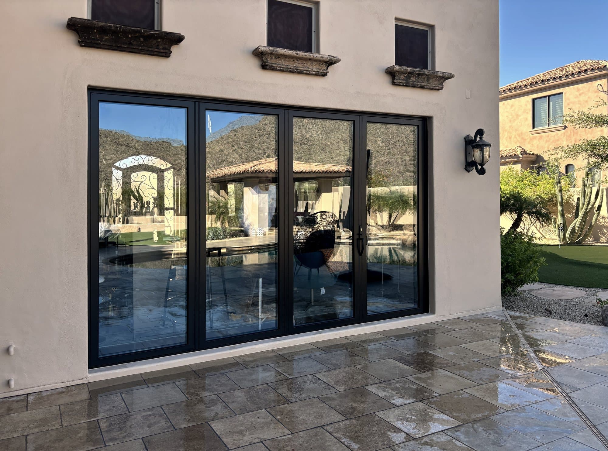 Four-panel black sliding patio door on a Spanish-style home, installed by Radiant Wall